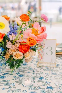 Coral and blue flowers beside a gold table number