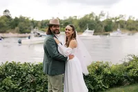 Couple embracing beside the water after the ceremony
