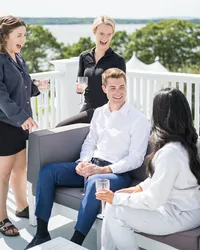 Groom laughing with family on the porch before the ceremony at French's Point