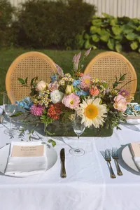 Garden style florals on a long table with rattan chairs