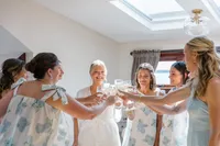 Bride and bridesmaids raising a toast while getting ready