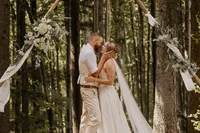 Brautpaar bei einer freien Trauung im Wald im Aargau, inniger Moment unter einem mit Blumen geschmückten Traubogen, natürliche und emotionale Hochzeitsreportage einer Hochzeitsfotografin aus der Schweiz mit authentischem Storytelling und ungestellten Momenten.