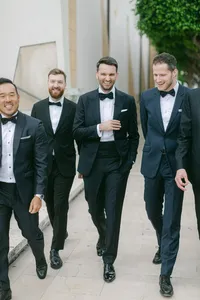 Groomsmen walking together in tuxedos – stylish and joyful moment captured at an Italy destination wedding.