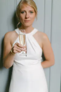 Mariée tenant une coupe de champagne pendant une réception de mariage élégante à Nantes.