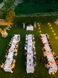 Luxury outdoor wedding dinner under string lights in Italy – elegant reception with long tables and guests celebrating under the stars
