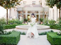 Mariée élégante dans les jardins d’un palace parisien, tenue de créateur et bouquet raffiné – Photographe mariage luxe Paris