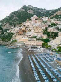 Positano beach lined with elegant blue umbrellas, a refined setting for seaside wedding portraits on the Amalfi Coast.