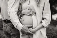 a husband cradles his wives bump during their maternity session