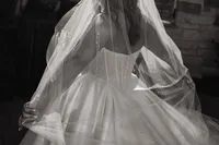 a bride adjusts her veil during her first look with her father