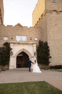 a bride and groom exit their ceremony and walk in to their castle venue in rockwall,texas.