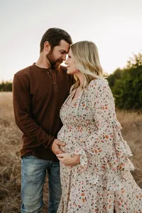 a husband and wife embrace her growing belly during her maternity session with shelly voss