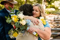 a mother of the bride embraces her son at the end of the aisle during their ceremony