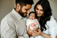 a new family holds their baby boy during their newborn session with shelly voss in carrollton,texas.