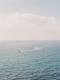 Kohnur ocean horizon view from a coastal cliffside showing vast blue water and a distant boat Amalfi Coast Salerno Italy
