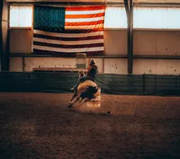 person-rides-a-horse-around-a-sharp-turn-indoors