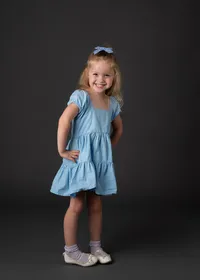 A cute young girl smiling for her school portrait session.