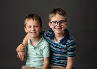 Two young brothers smiling for their school picture.