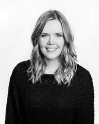 Black-and-white-headshot-of-woman-with-blonde-hair-and-black-sweater