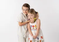 A school-aged brother and sister posing for their school picture.
