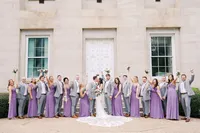 An elegant, joyful wedding party photo taken on the steps of the Capitol building in downtown Raleigh, North Carolina, capturing sophisticated city vibes and celebratory energy by North Carolina wedding photographer Jessica Leigh Mason.
