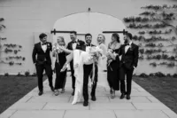 A groom carrying his bride while the bridal party walks behind