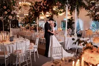 A photo of the bride and groom kissing in their reception room