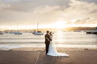 The bride and groom looking out across the harbour towards the sunset at their Watson's Bay wedding