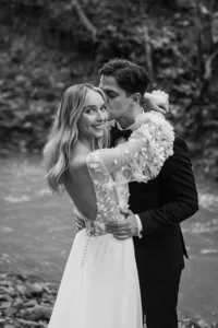 Bride looking over her shoulder as the groom kisses her cheek