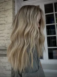 a cool toned blonde with long hair in beachy waves and lots of dimension at Moxie Hair Studio