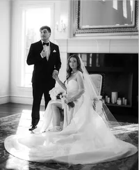 Black and white image of husband and wife in front of a fire place filled with candles
