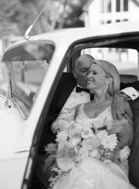 man and wife in v-neck wedding dress in a car kissing