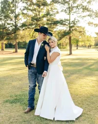Man and wife in a high neck wedding gown and cowboy hat