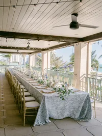 Long feasting table set up for colorful garden beach wedding