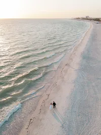 Bride and groom walking on beach