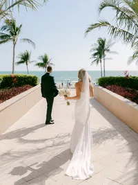 Bride and groom photo in front of Lido Beach with palm trees
