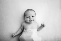 Timeless black and white newborn portrait of a smiling baby, taken by a professional photographer in the Waukesha and Lake Country area.