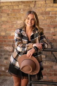 A girl from Catholic Memorial High school leans against an iron railing in front of a brick wall in Milwaukee's Third Ward for her senior picture.