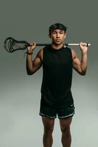 A young man from Catholic Memorial High School poses for his senior portraits with his Lacrosse equipment in our Waukesha studio.
