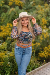 A student from Catholic Memorial High School poses for her senior portraits on the boardwalk in Waukesha's Retzer Nature Center.