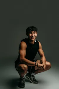 A student form Waukesha South High School poses for his senior photos wearing a black muscle shirt in our studio.