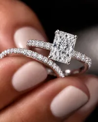 Radiant cut diamond engagement ring with pavé diamond band on hand