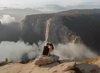 photograph of a bride and groom enjoying the views of their destination elopement in yosemite with el capitan and smoke billowing in the background