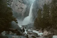 bride and groom at the base of yosemite falls at their destination elopement in Yosemite national park