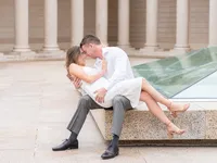 Couple posing for a romantic spring engagement portrait in front of an old building during a photo session.