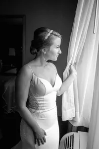 Black and white photo of a bride at a hotel window in Downtown Los Angeles with soft natural light
