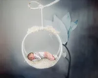 Los Angeles newborn photography artistic studio portrait of a newborn in a prop basket suspended in the air, styled safely with soft light and true to life color.