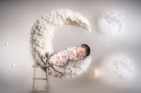 4Karma Studio - A creative fine art newborn portrait in Los Angeles featuring a baby sleeping on a crescent moon composite with whimsical styling and true-to-life colors.