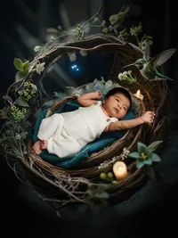 4Karma Studio - A whimsical fine art newborn portrait of a baby in a handwoven basket reaching for a hummingbird, featuring creative composite artistry in Los Angeles.