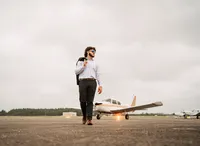 Senior portrait at a small hangar near Mobile International Airport in Mobile, Alabama — walking
Senior portrait at a small hangar near Mobile International Airport in Mobile, Alabama — suit
jacket over his shoulder, wearing aviators with the plane in the background.