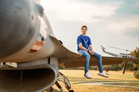 Senior portrait at Battleship Memorial Park in Mobile, Alabama— sitting on the wind of an f16 fighter jet.
